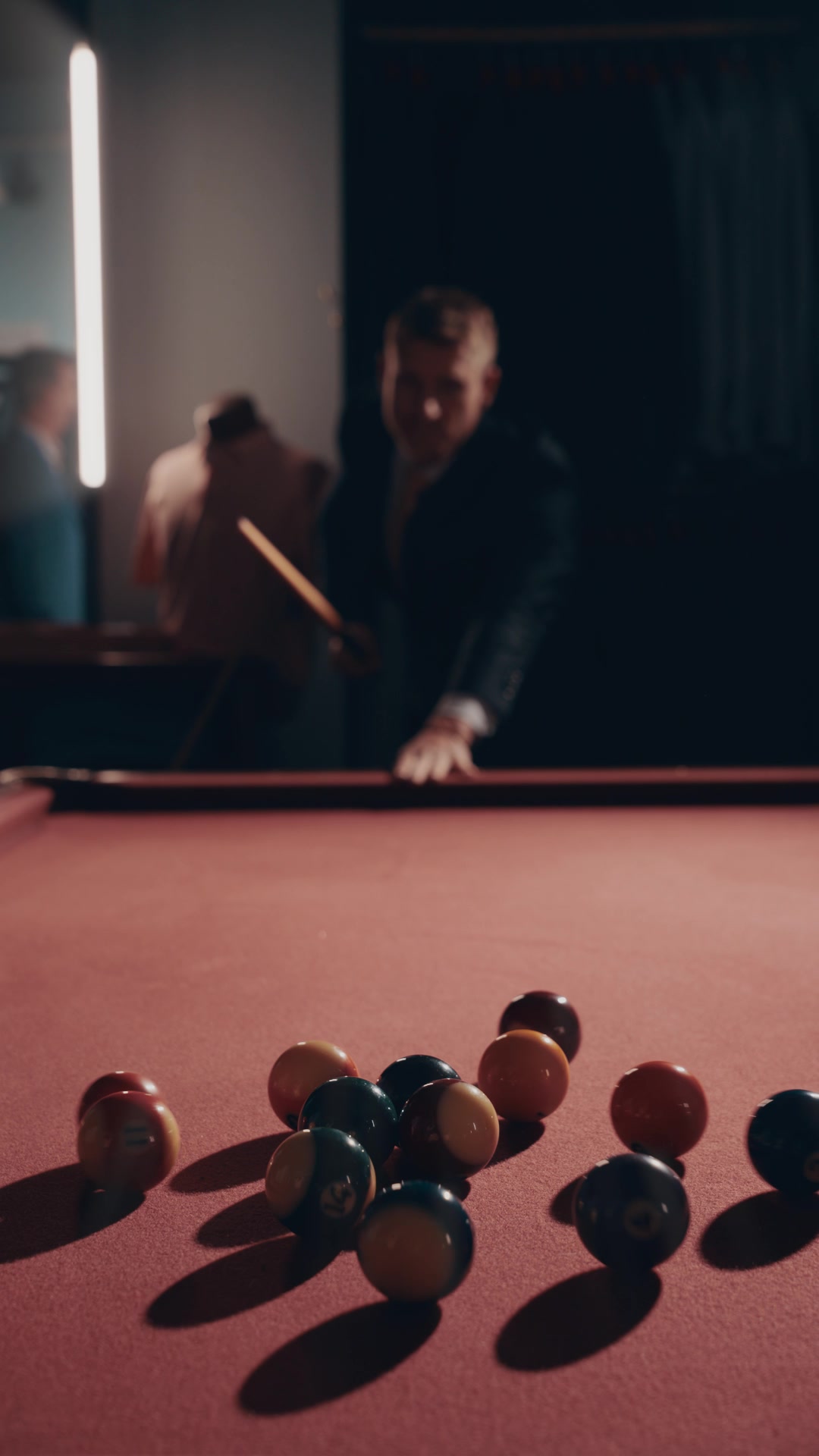 Customer in a Lafferty's suit lining up a shot at the pool table